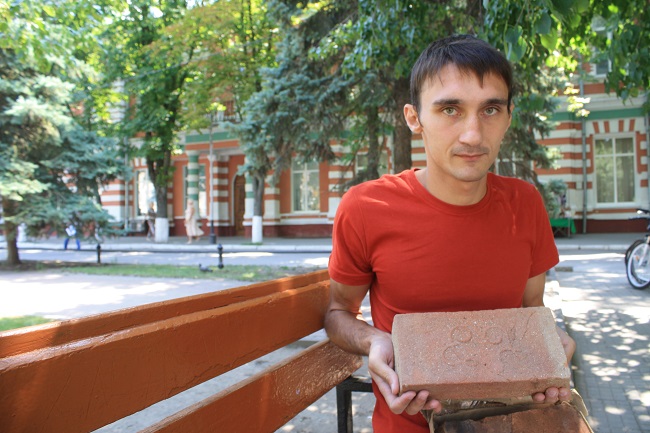 Азовский археолог Дмитрий Зенюк с кирпичами, где есть знаки староалбанского алфавита